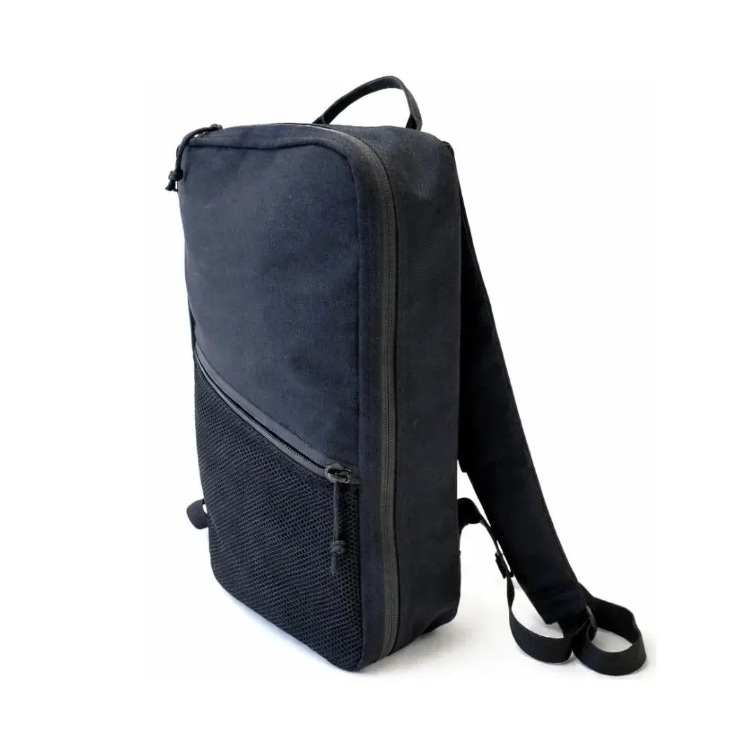 Black canvas backpack with mesh front pocket and single strap.