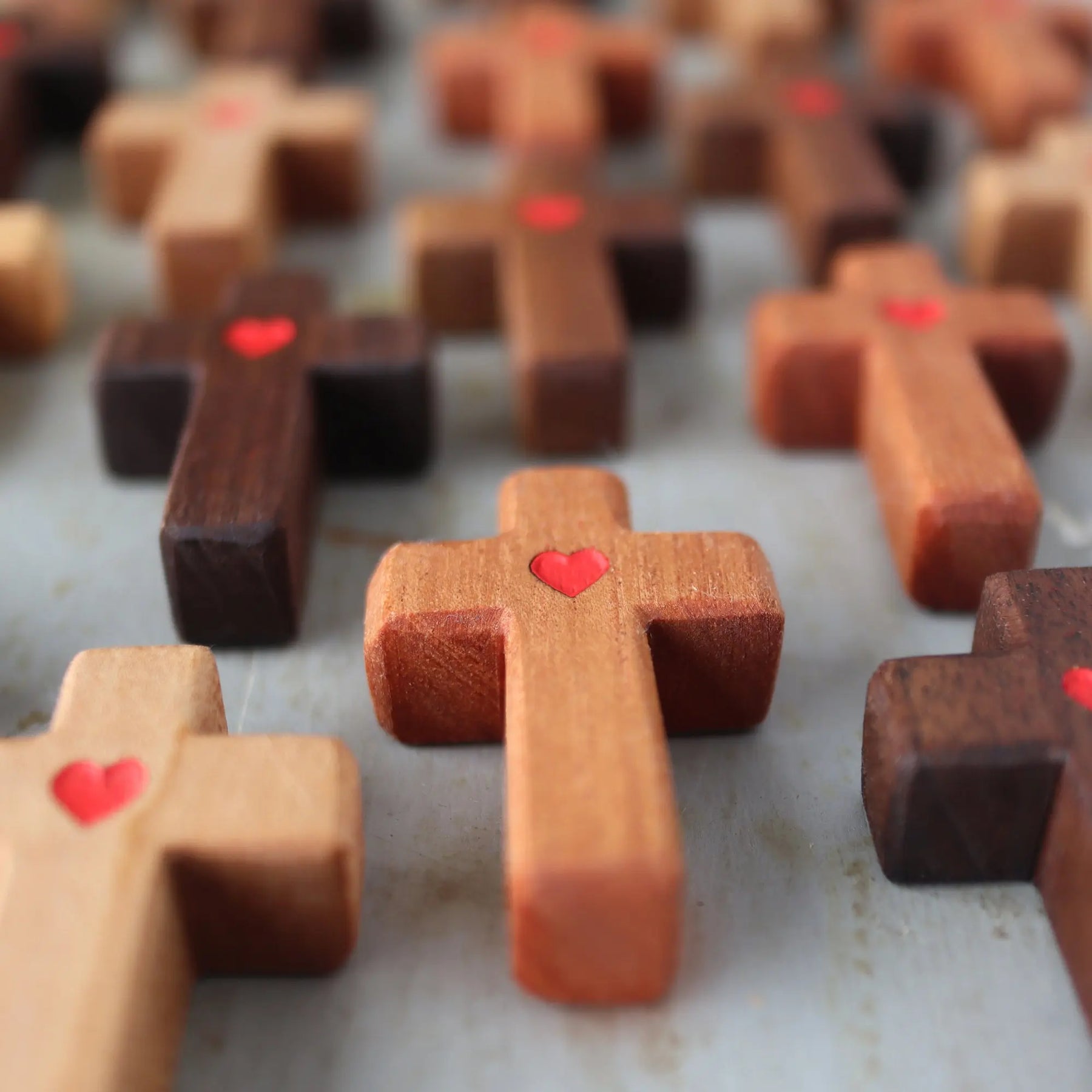 Agape Pocket Crosses with red heart details in various wood tones