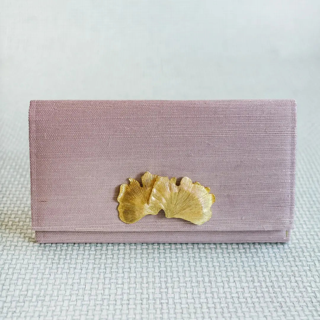 Lavender grasscloth clutch with gold ginkgo leaf embellishment and magnetic snap closure.