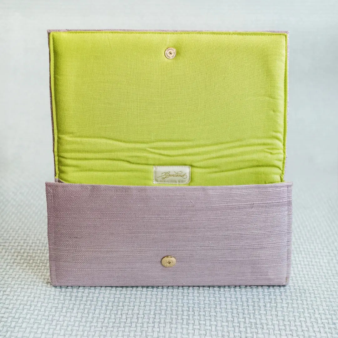 Lavender grasscloth clutch with lime green linen interior and gold snap closure.