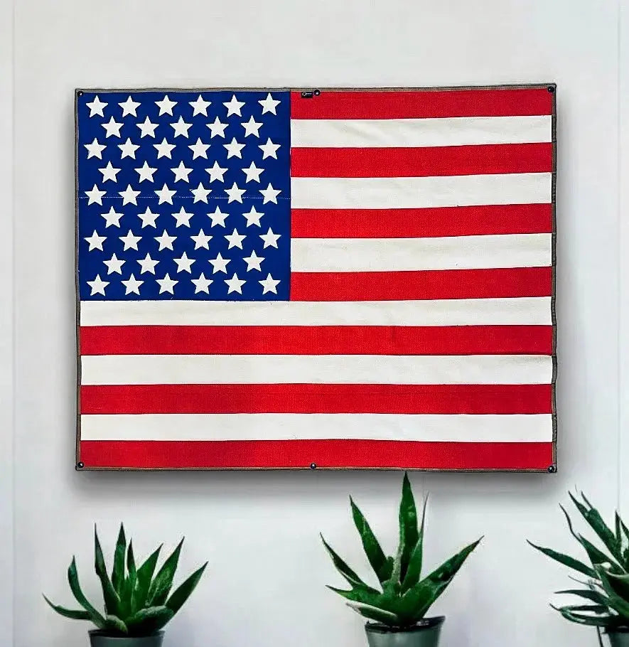 Wall-mounted American flag made from red and white fire hose fabric.