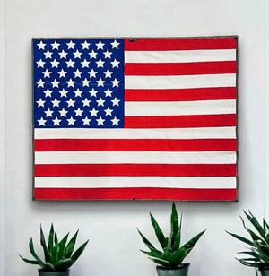 Wall-mounted American flag made from red and white fire hose fabric.