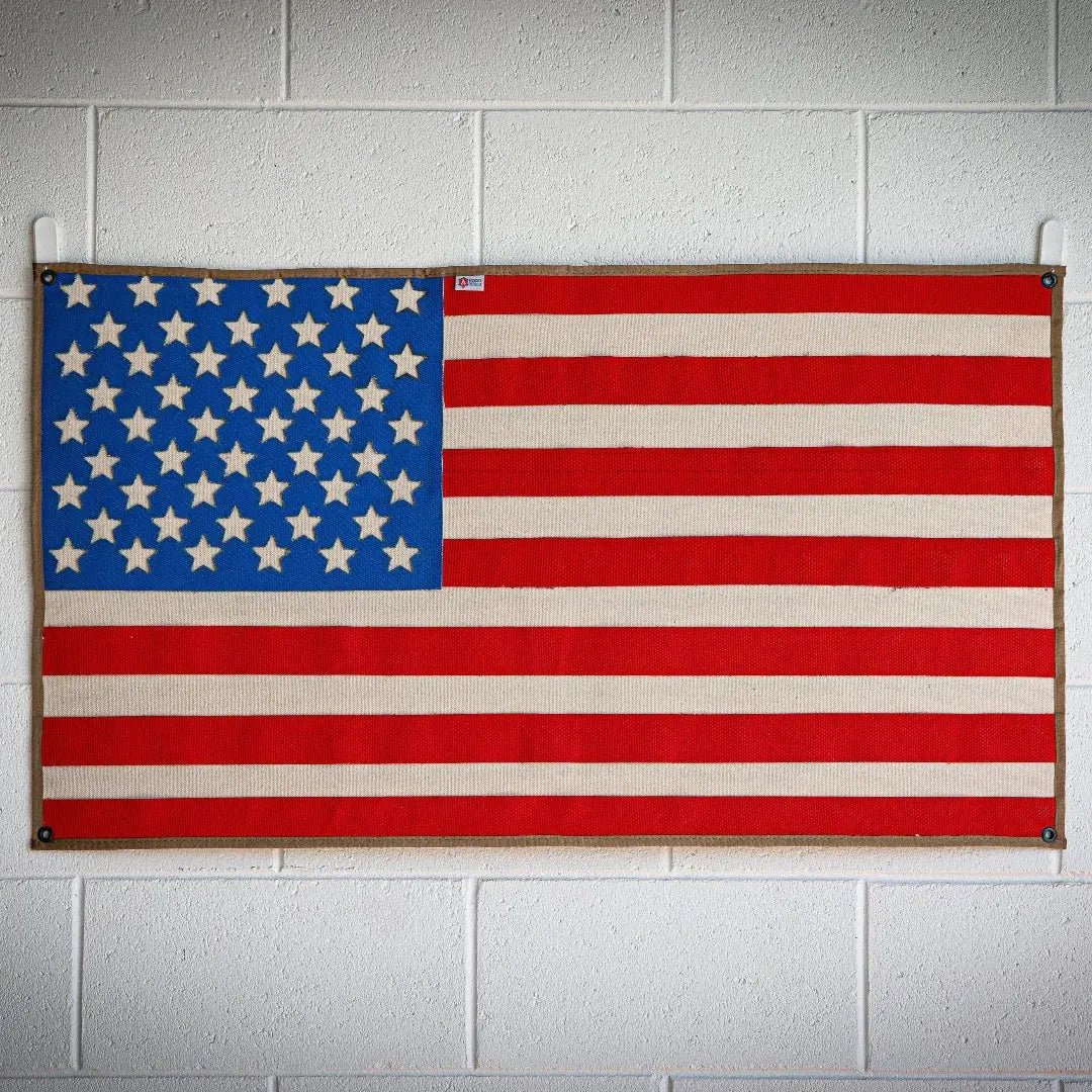 American flag made from woven red, white, and blue fire hose with stars.