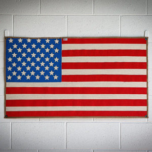 American flag made from woven red, white, and blue fire hose with stars.
