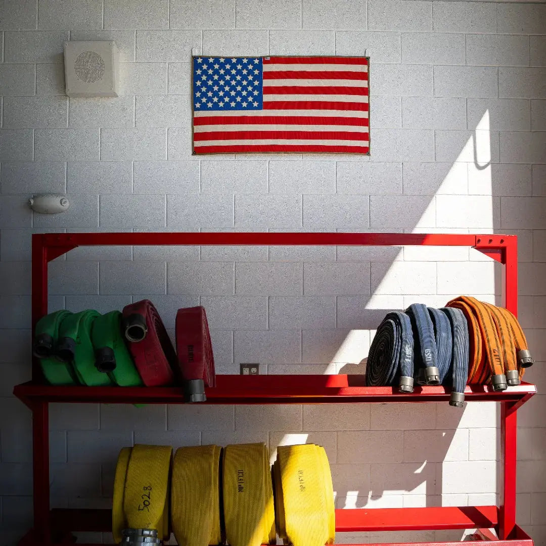 American flag made of coiled red, white, and blue fire hose.