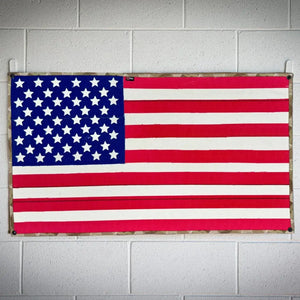 American flag with blue union, white stars, and red and white stripes on a camouflage border.