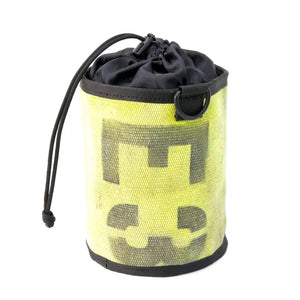 Yellow cylindrical gear bag made from recycled fire hose with black logo