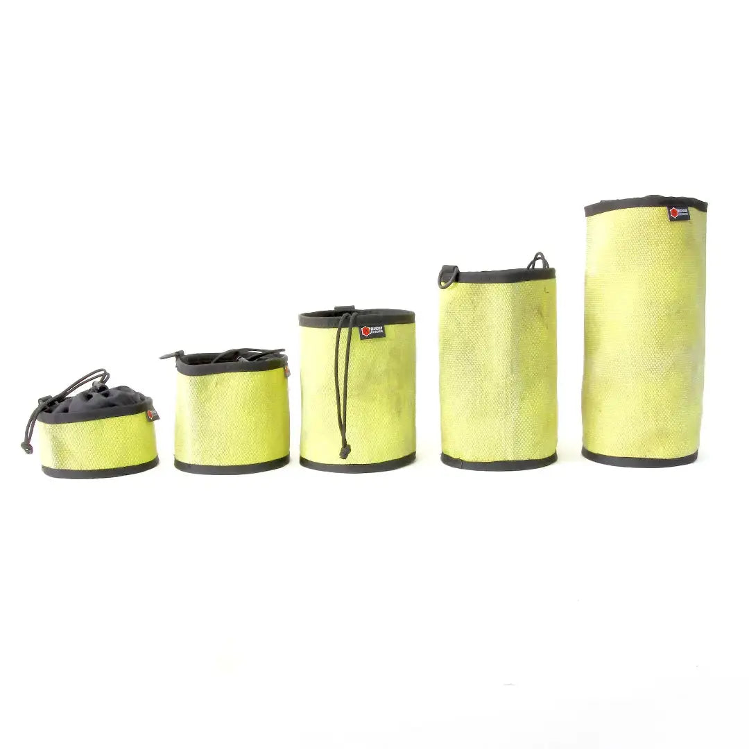 Five yellow recycled fire hose gear bags in ascending sizes.