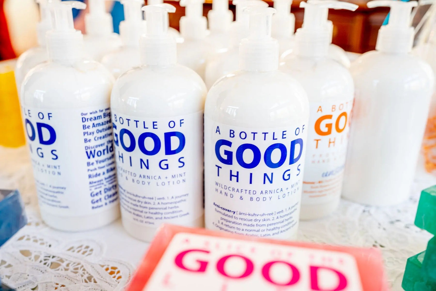 White pump bottles of Arnica + Mint hand and body lotion.