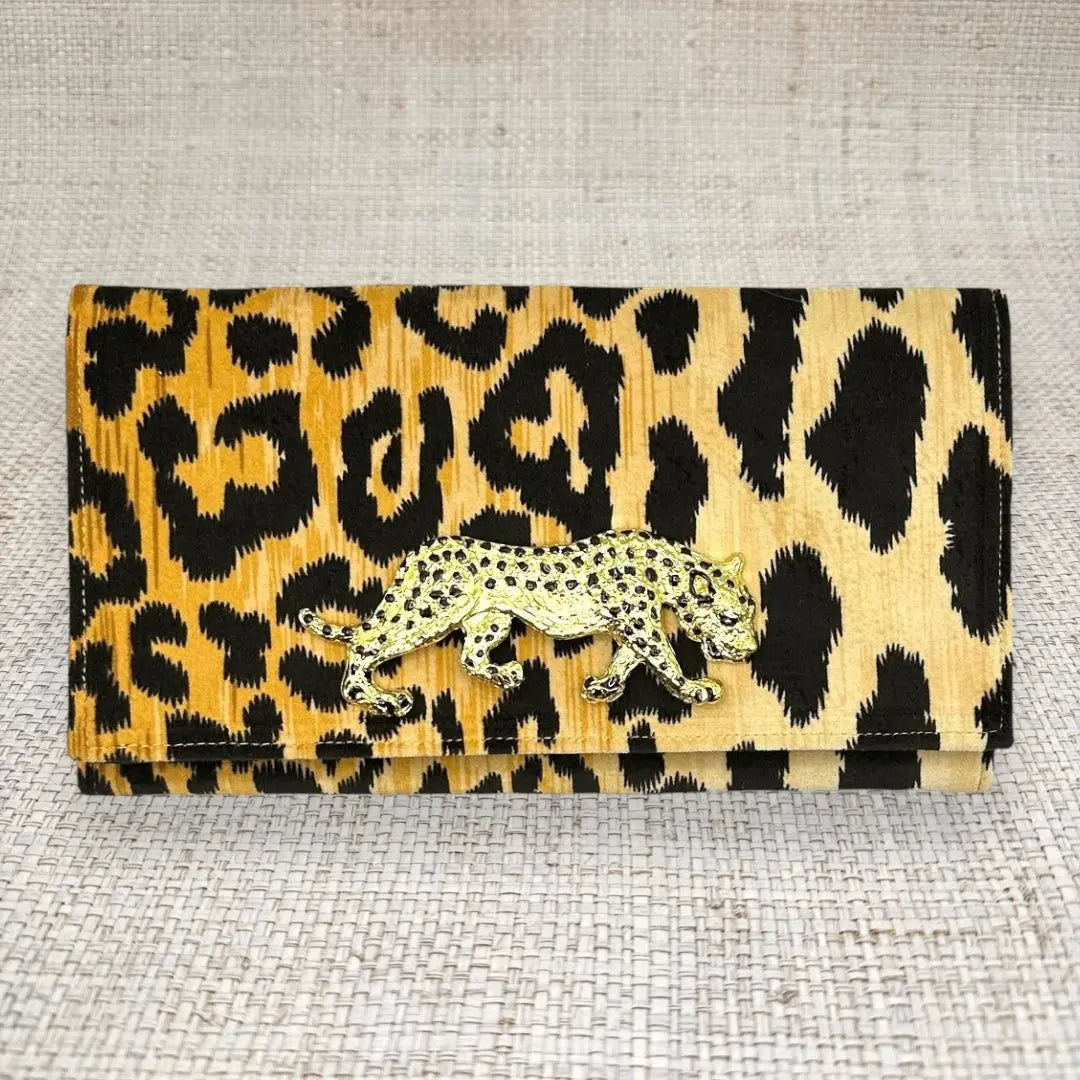 Leopard print clutch with a gold cheetah embellishment.