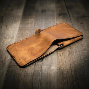 Brown leather bifold wallet open on a wooden surface.