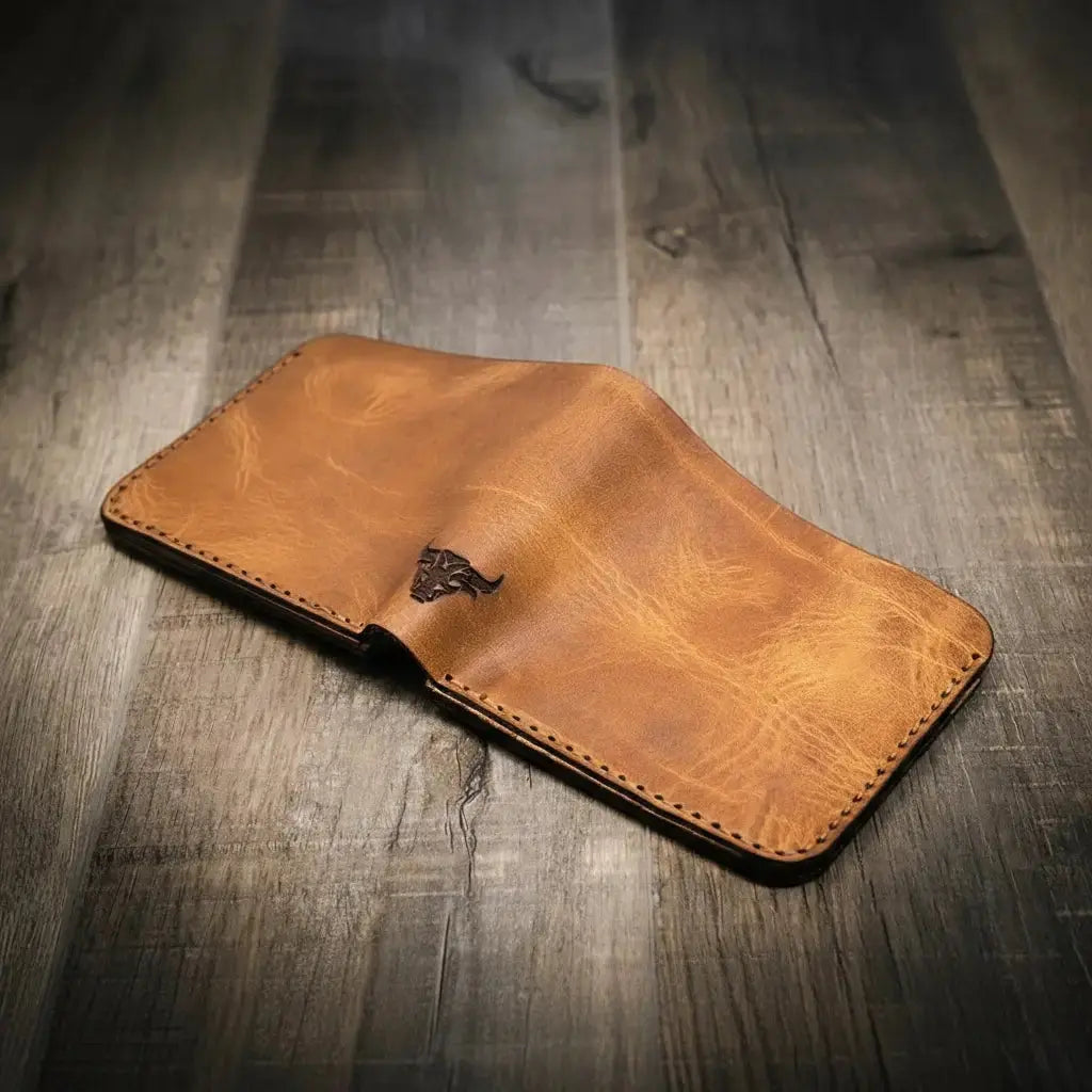 Brown leather bifold wallet with a bull emblem on a wooden background.