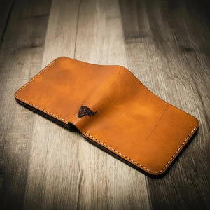 Brown leather bifold wallet with bull emblem and stitching