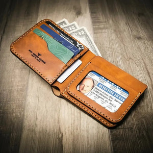 Brown leather bifold wallet with card slots, cash, and an ID window showing a driver's license.