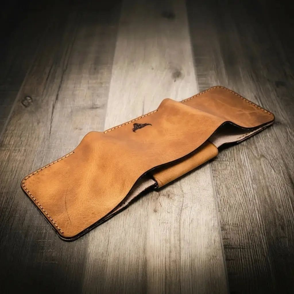 Leather trifold wallet with embossed bull logo on a wooden background