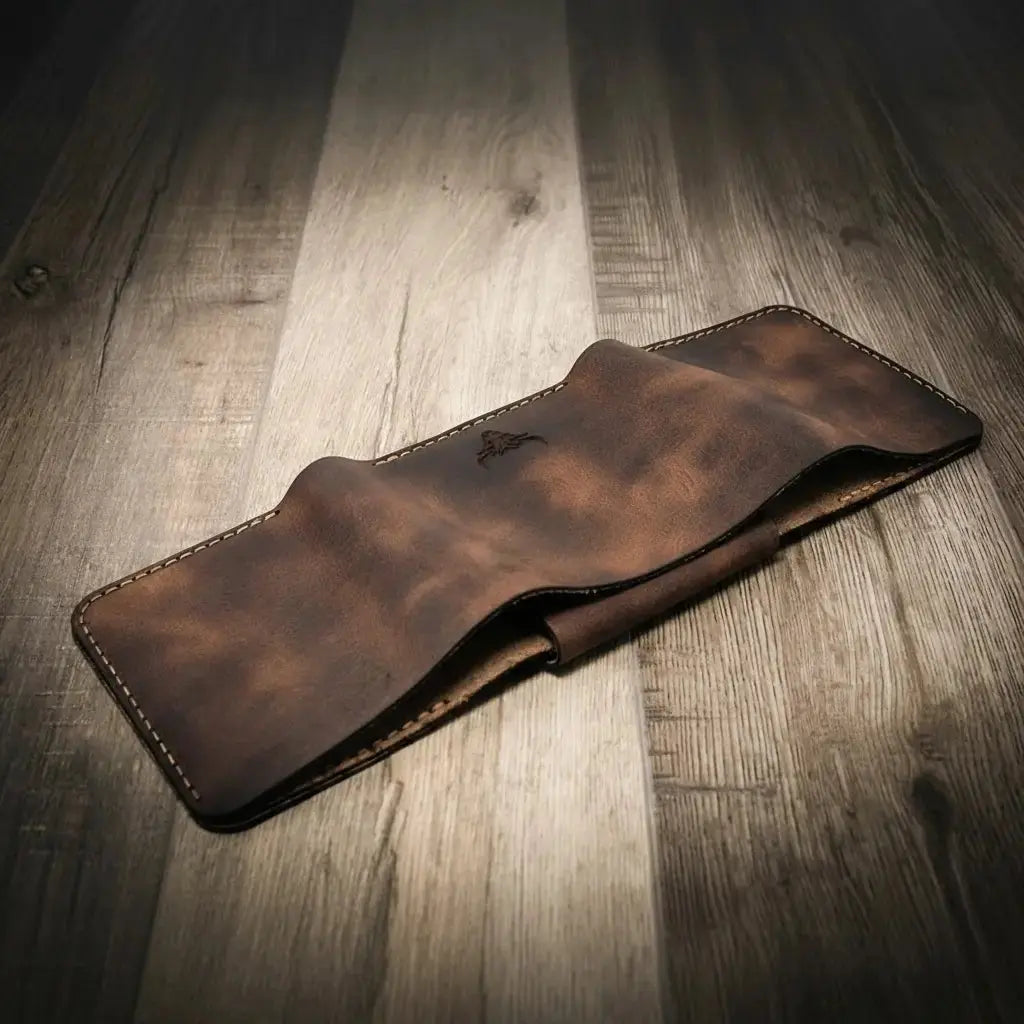 Distressed brown leather trifold badge wallet on a wooden surface.
