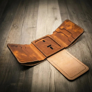Brown leather trifold wallet with badge holder and card slots on wooden surface
