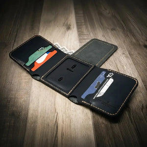 Black leather trifold wallet with card slots and cash pocket, open on a wooden surface.