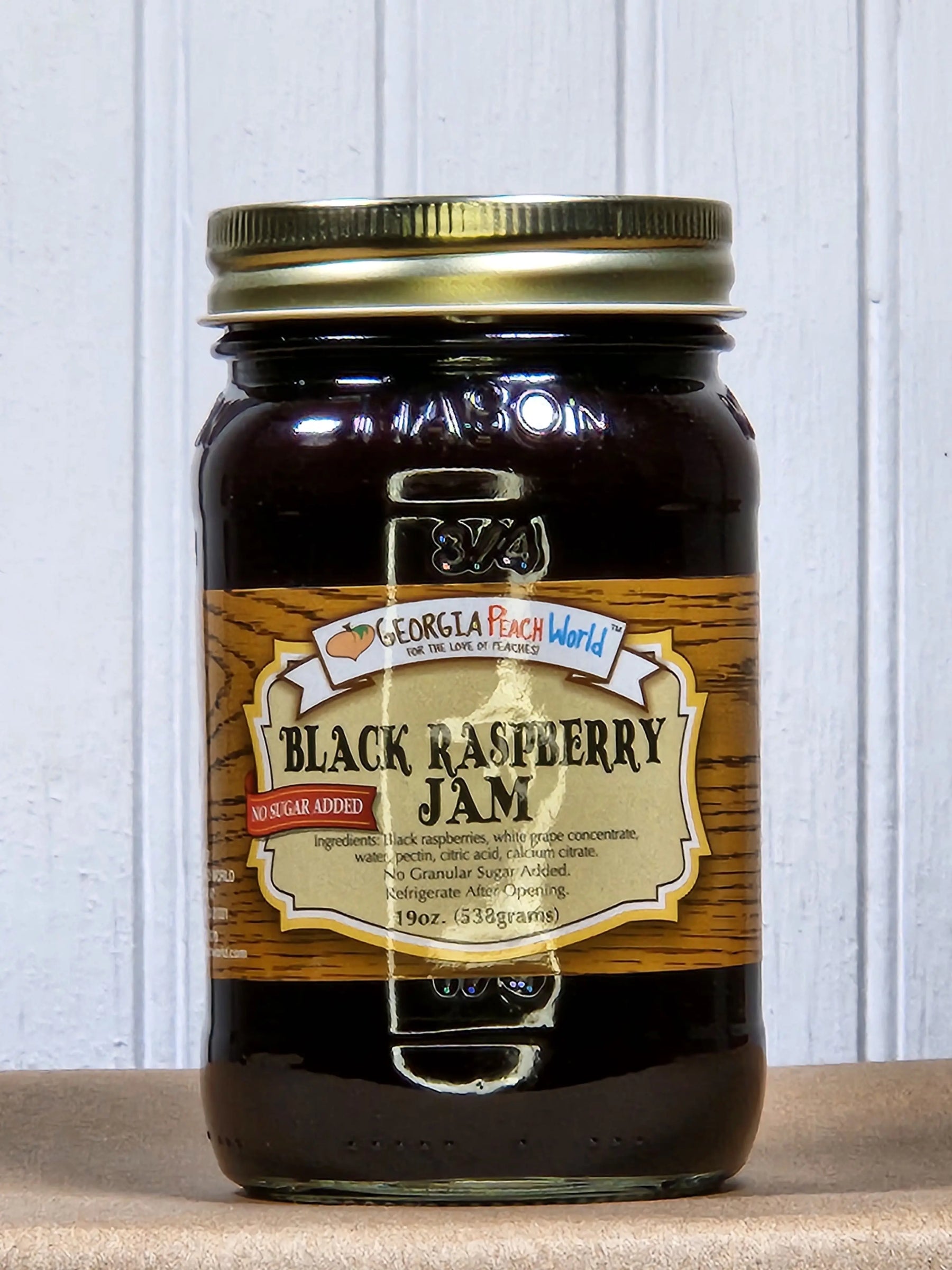 Glass jar of Georgia Peach World Black Raspberry Jam with 'No Sugar Added' label.