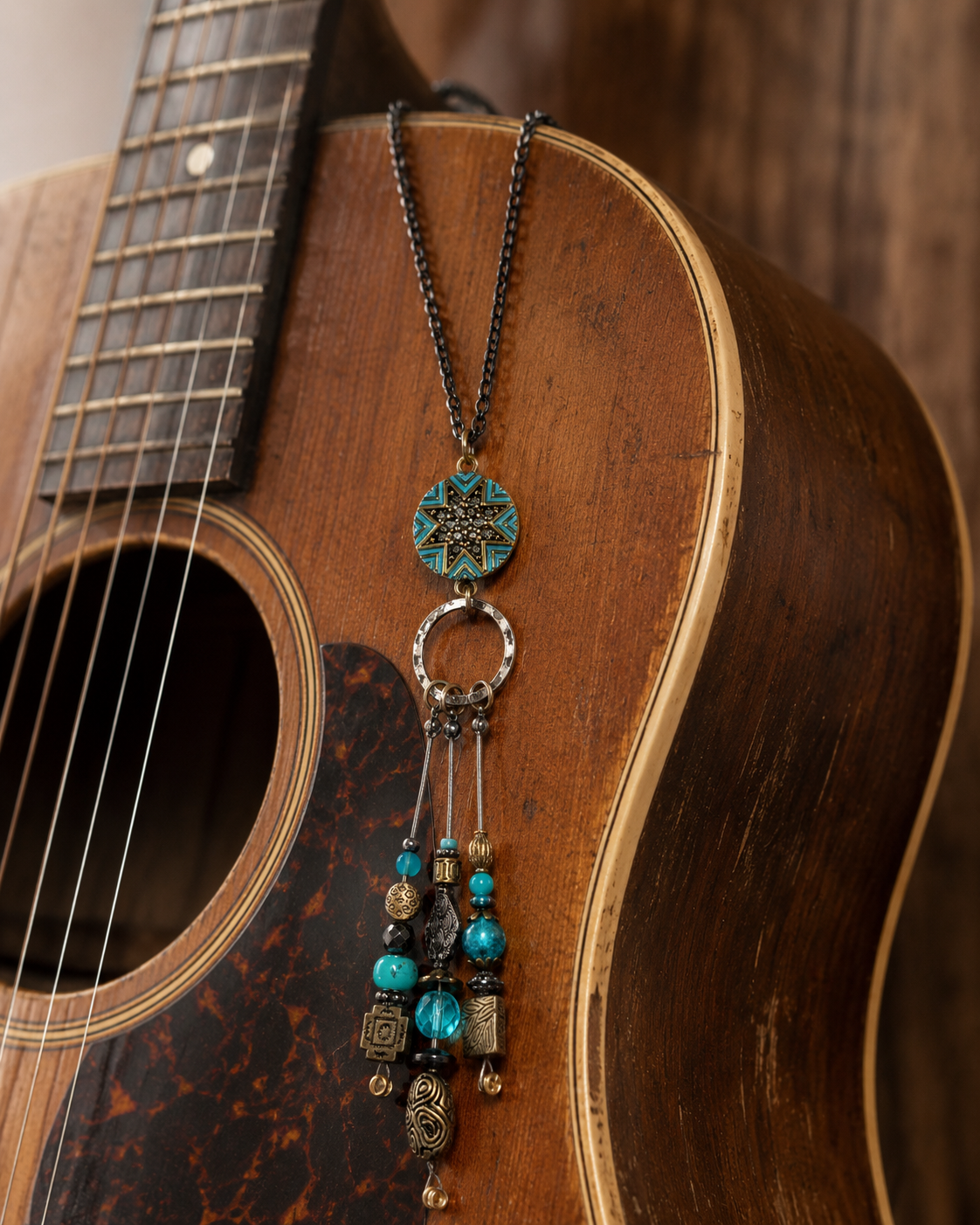 Necklace with decorative pendant on an acoustic guitar