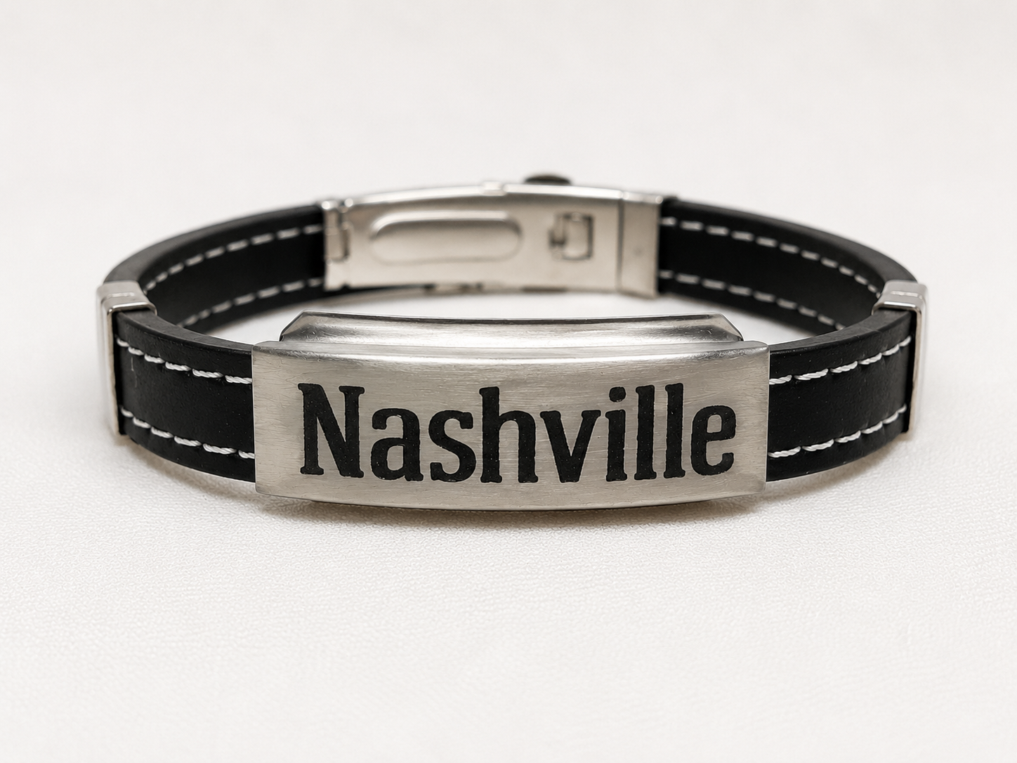 Black leather bracelet with silver clasp and 'Nashville' engraving on a white background