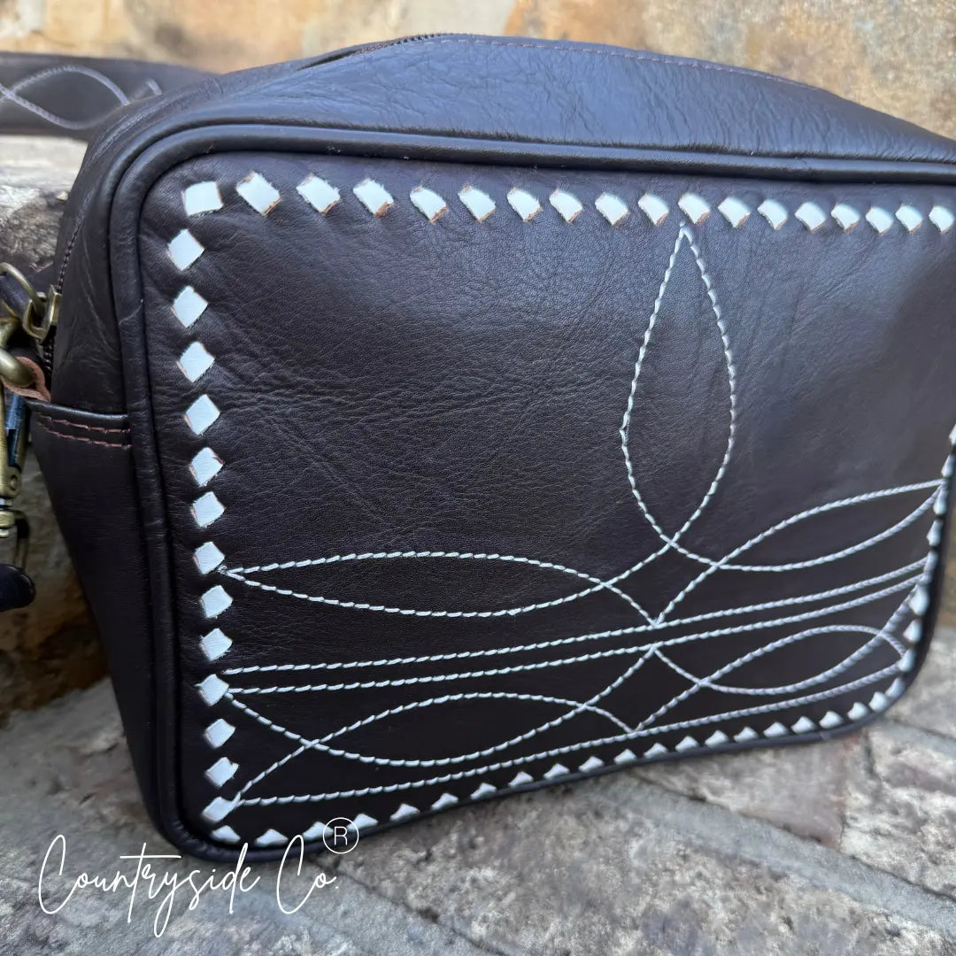 Brown genuine leather purse with white boot stitch embroidery and strap.