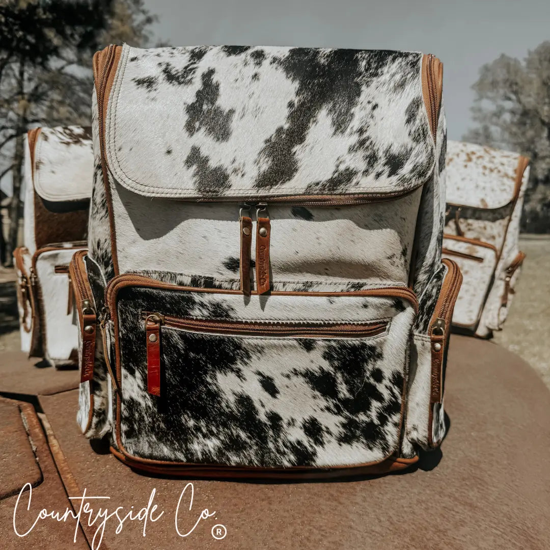 Boulder cowhide backpack with leather trim and multiple zippered pockets.