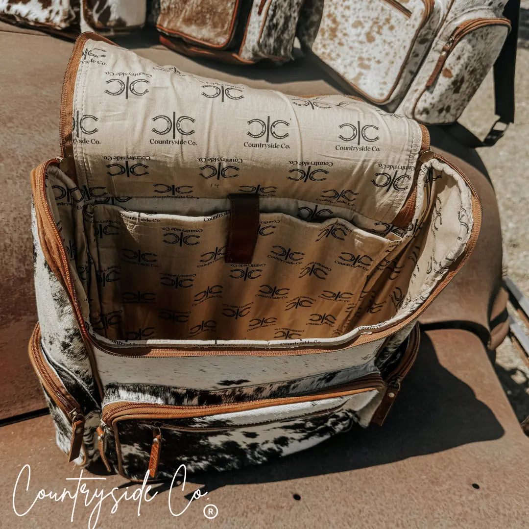 Open Boulder Cowhide Conceal Carry Backpack showing interior pockets with "Countryside Co." logo lining.