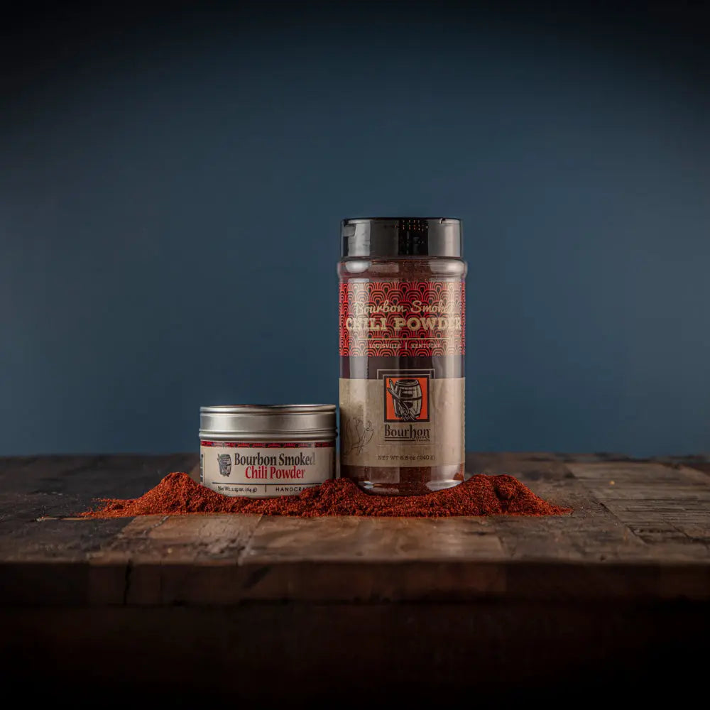 Bourbon Smoked Chili Powder in tin and shaker with spilled chili powder