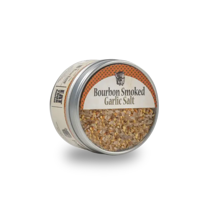 Bourbon smoked garlic salt in a tin with visible dehydrated garlic pieces.