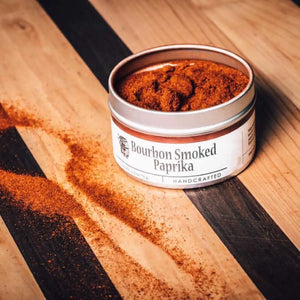 Bourbon Smoked Paprika spice in a tin on a wooden board.