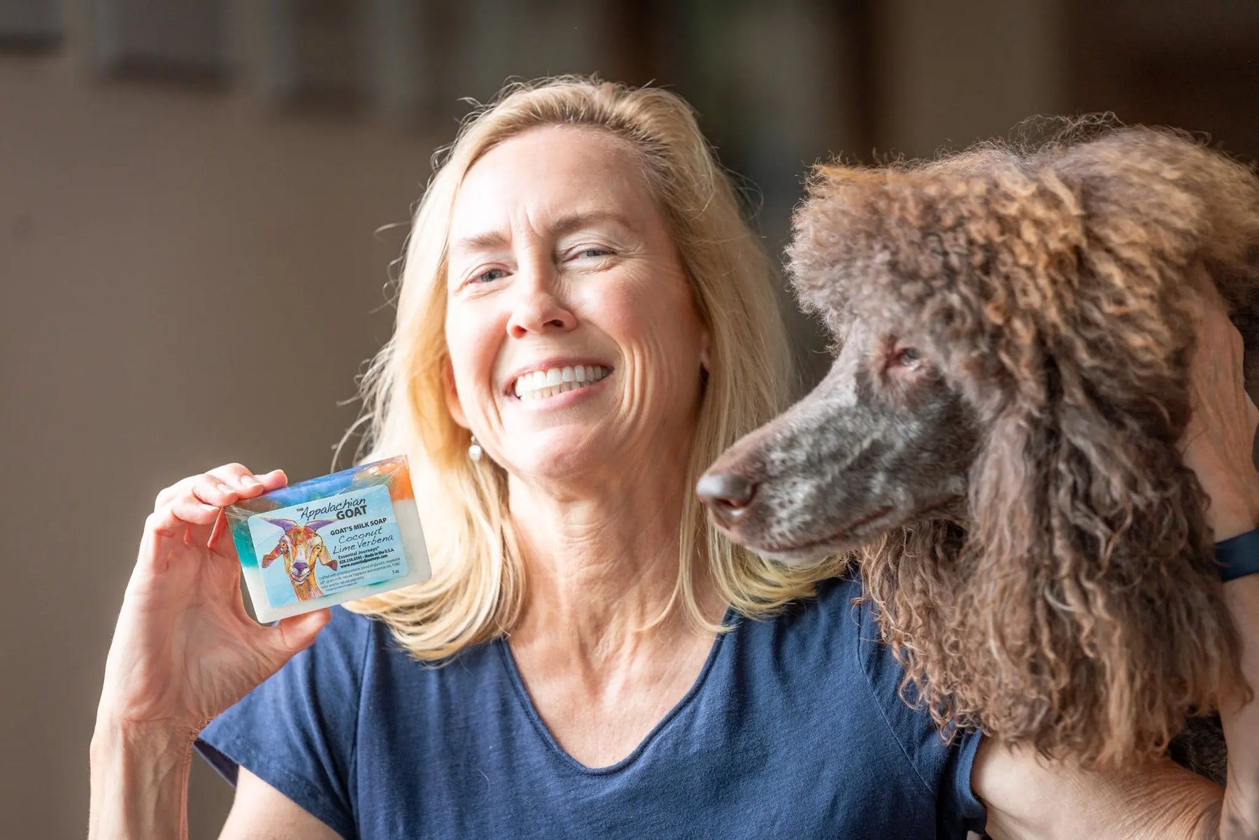 Woman holding Appalachian Goat milk soap with dog next to her