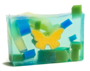 Coconut Lime Verbena soap slice with yellow butterfly and blue and green geometric shapes embedded.