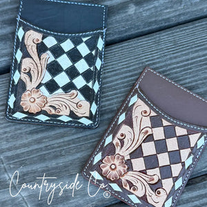 Two checkered tooled leather credit card holders in black and brown on a wooden surface.