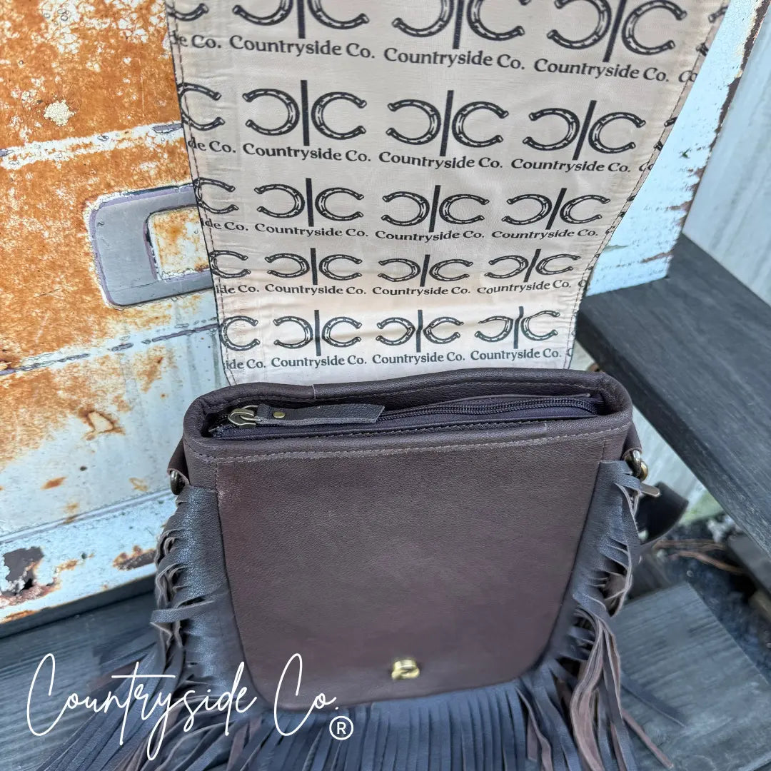 Brown leather fringe crossbody purse with "Countryside Co." logo lining