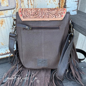 Brown tooled leather crossbody bag with floral design and fringe detail.