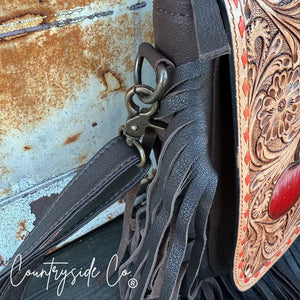 Brown leather purse with red heart detail and fringe, metal clasp detail.