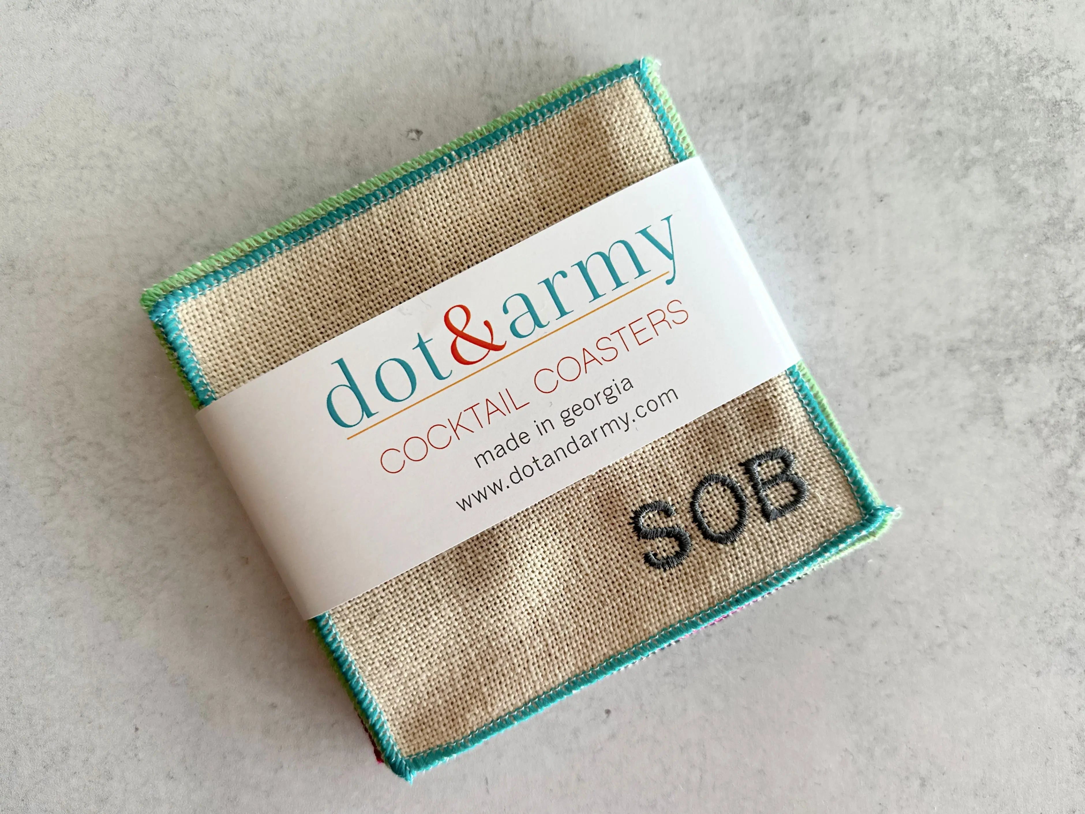 Set of 8 burlap cocktail coasters with colorful stitched edges and "SOB" embroidered.