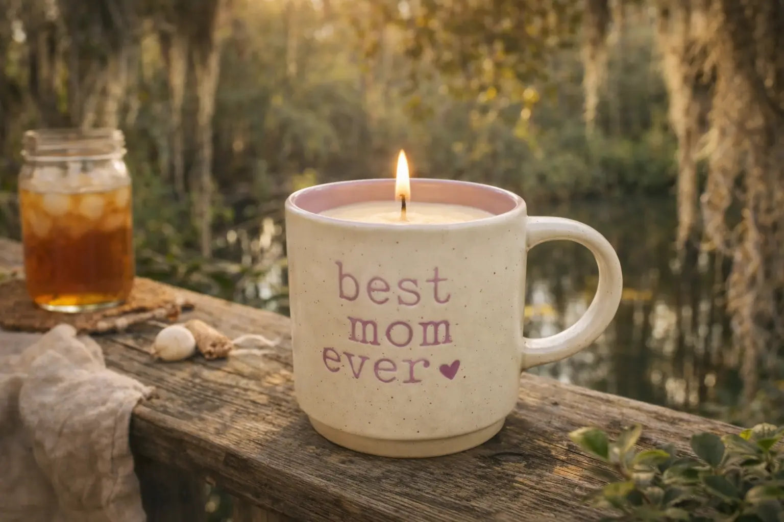 Cream mug candle with "best mom ever" text and a purple heart.