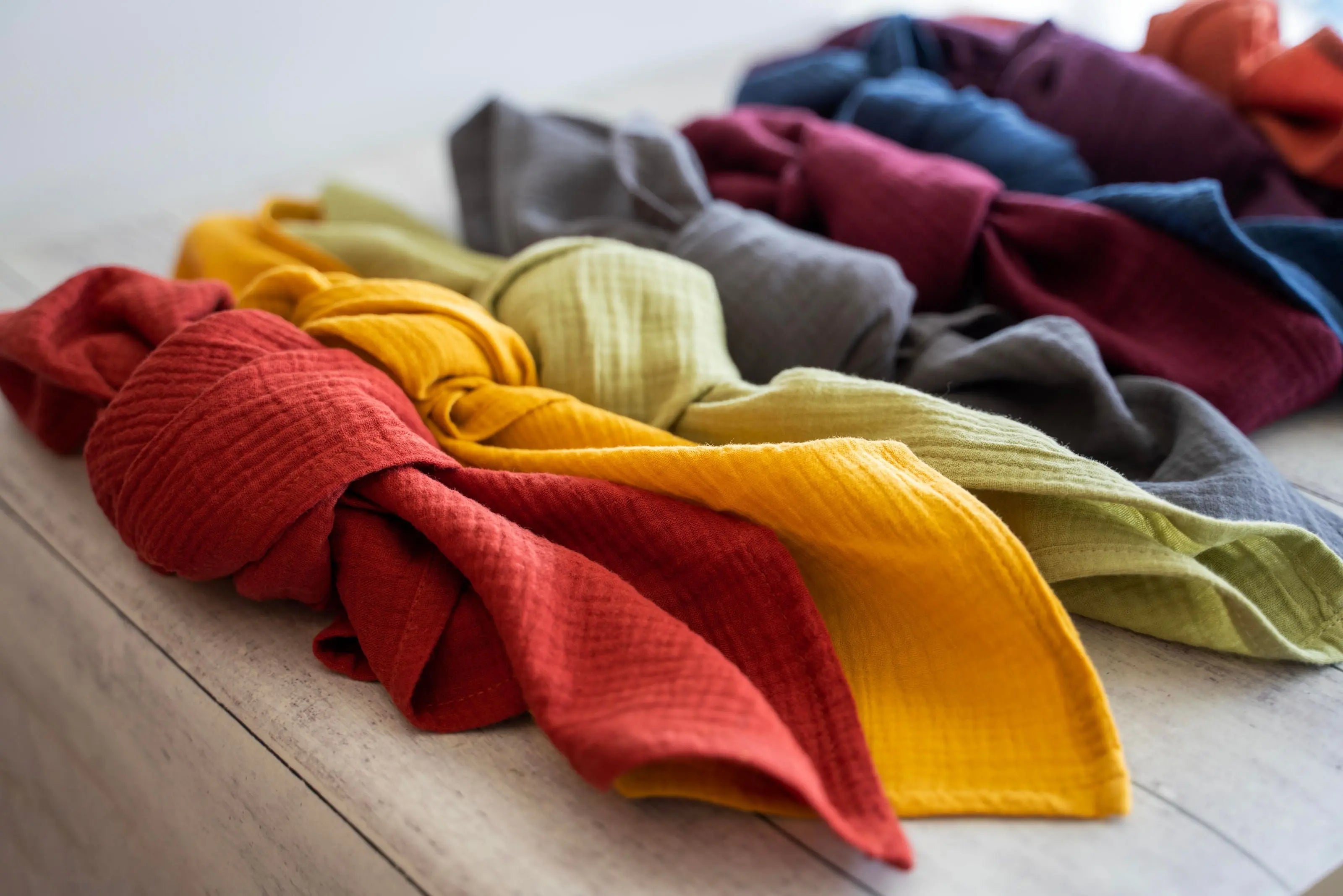 Set of four cotton crinkle cloth napkins in red, yellow, lime green, and gray.