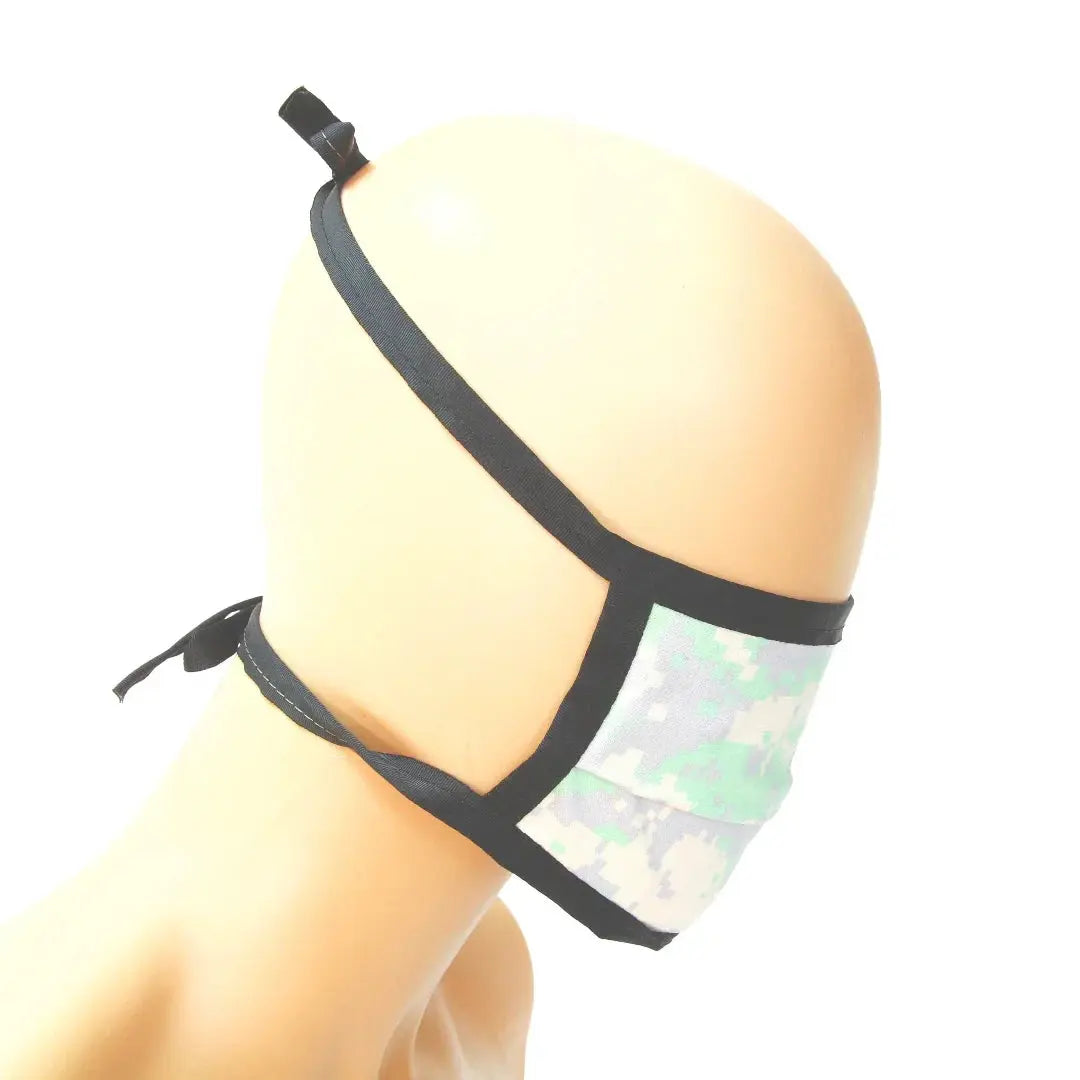 Cotton mask with digital camouflage print and black tie straps.