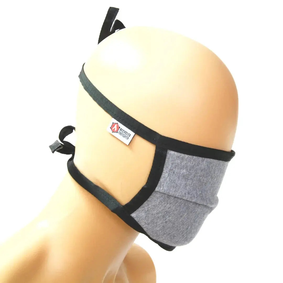 Grey cotton face covering mask with black trim and adjustable ties.