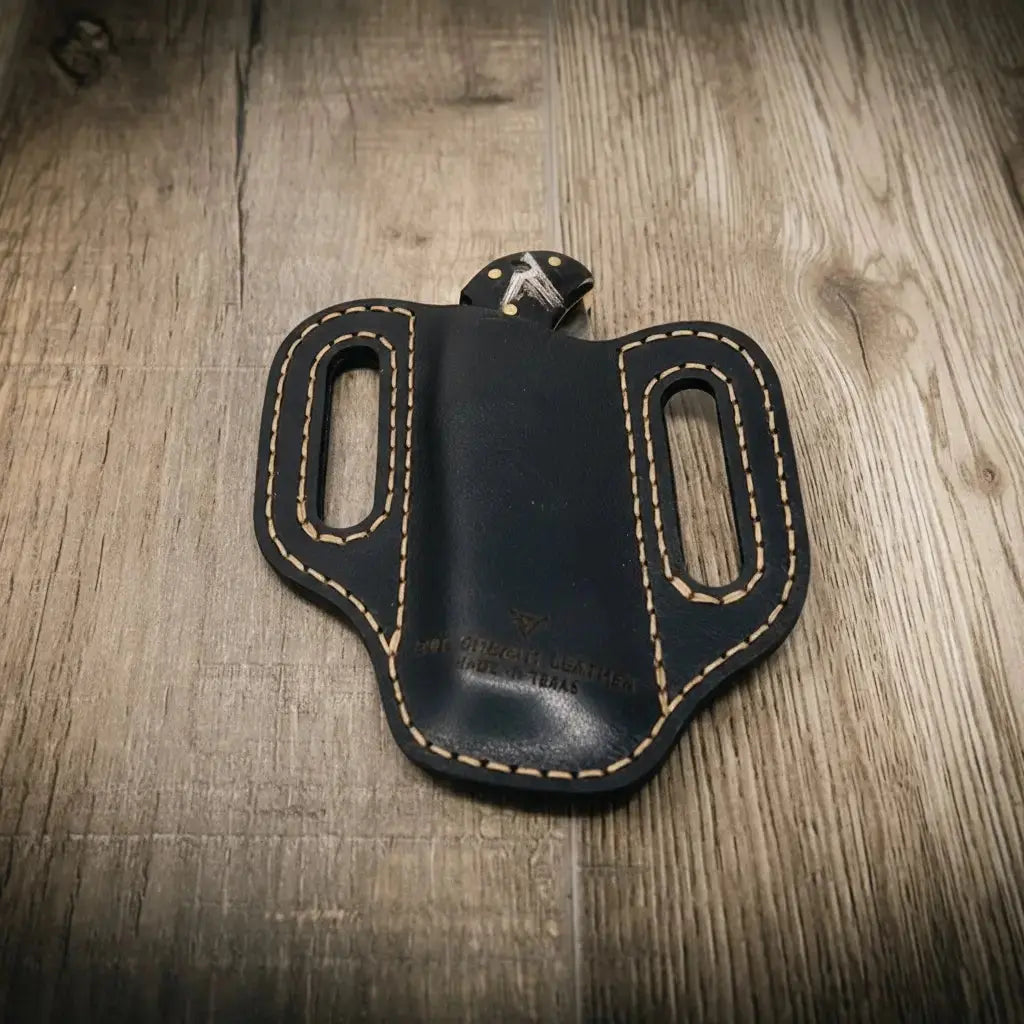 Black leather trapper knife sheath with contrast stitching and belt loops.