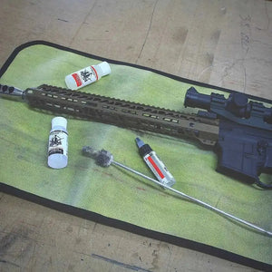 AR-15 rifle cleaning tools and supplies on a green drop zone mat.
