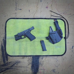 Firehose drop zone mat with pistol, holster, and magazine.