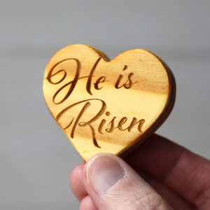 Wooden heart with "He is Risen" engraved for Easter.