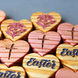 Engraved wooden heart shapes with crosses and floral designs for Easter.