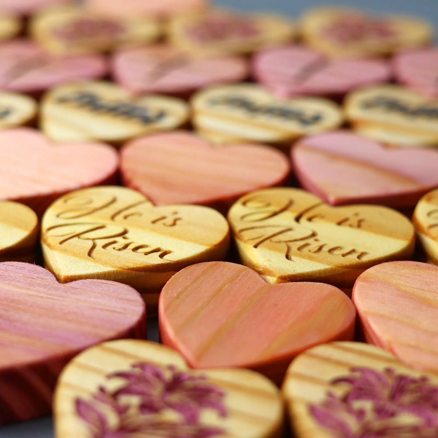 Engraved wooden hearts with Easter messages in pink and tan colors.