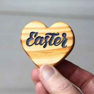 Wooden heart with the word "Easter" engraved in dark blue letters.