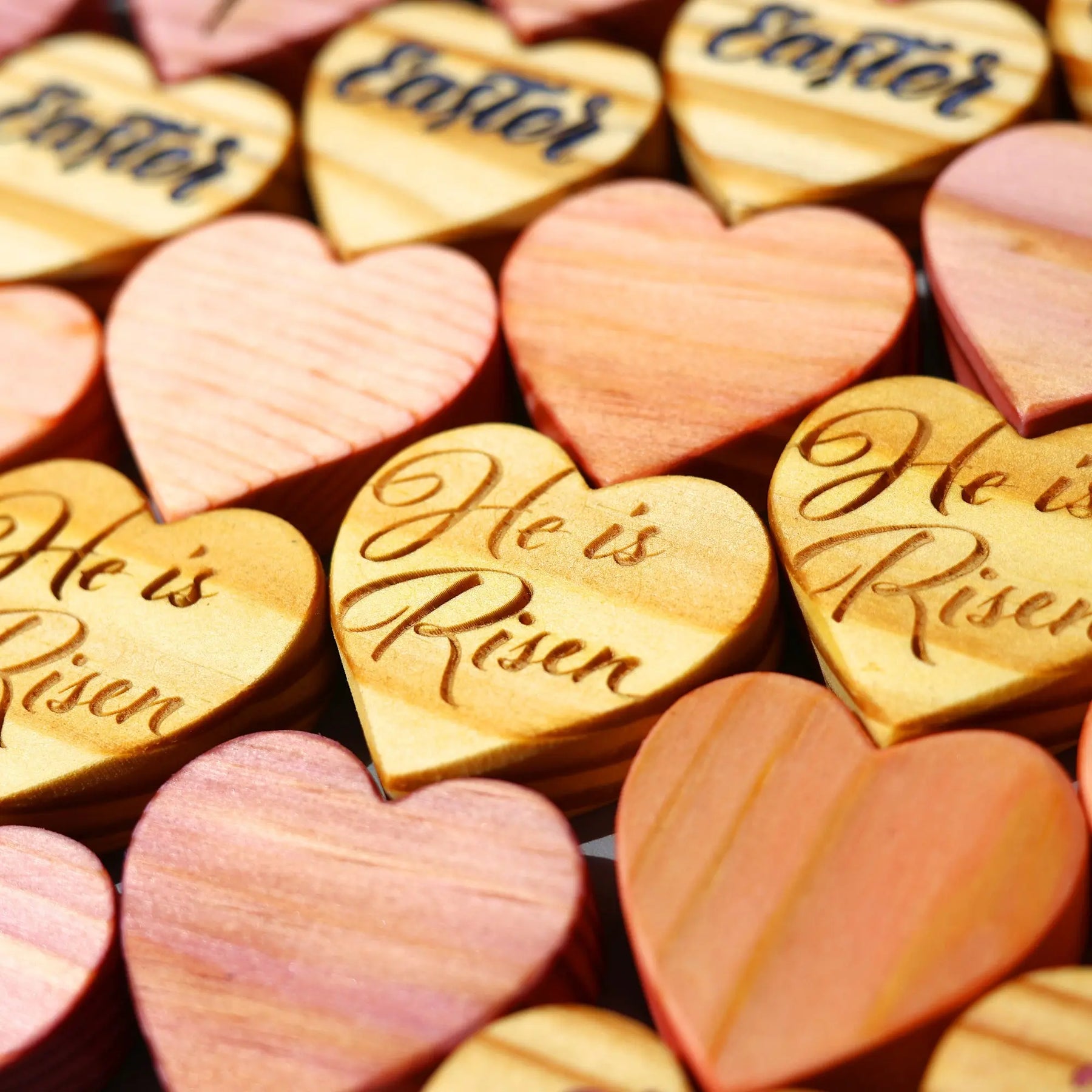 Wooden hearts engraved with Easter messages like "He is Risen."
